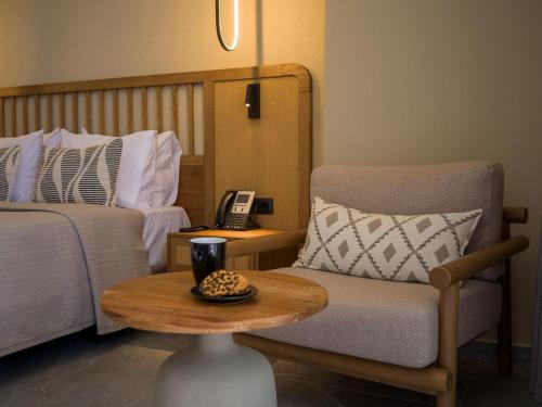 a living room with a chair and a coffee table at Portes Theros in Nea Potidaea