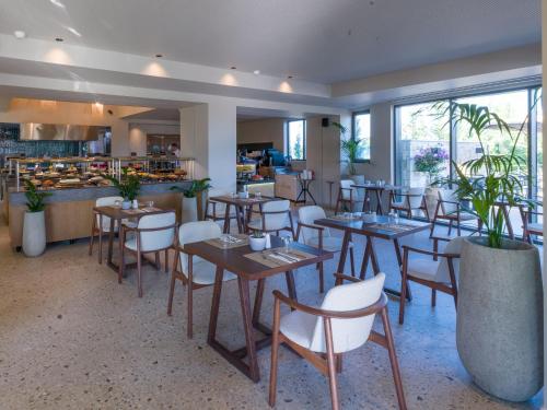 a restaurant with tables and chairs and a counter at Portes Theros in Nea Potidaea