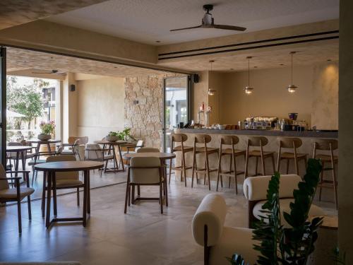 a restaurant with tables and chairs and a bar at Portes Theros in Nea Potidaea