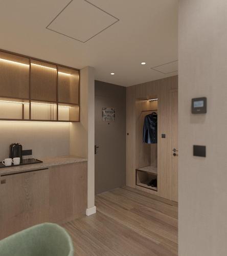 a kitchen with wooden cabinets and a green chair at Hyatt Place Tallinn in Tallinn