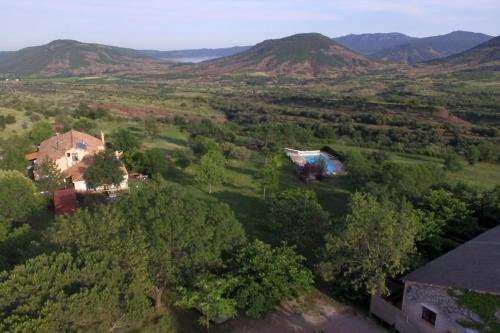 an aerial view of a house in a field with mountains at Gites au Cœur de la Nature, Piscine et Vue sur le Lac du Salagou in Le Puech
