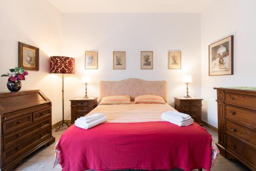 a bedroom with a large bed with a red blanket at Cappuccini Florence Family & Group 3 Bedrooms Jacuzzi Fast Wi-Fi Air Conditioned Tram in Florence