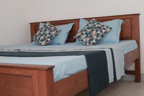 a wooden bed with two pillows on it at VD Rest Gampola in Gampola