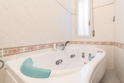 a white bath tub with a faucet in a bathroom at Cappuccini Florence Family & Group 3 Bedrooms Jacuzzi Fast Wi-Fi Air Conditioned Tram in Florence
