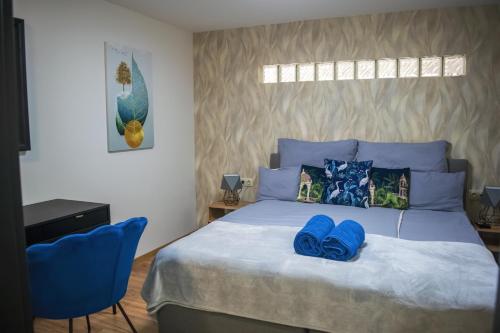 a bedroom with a large bed with blue pillows at Oázis Tapolca Apartman in Miskolctapolca