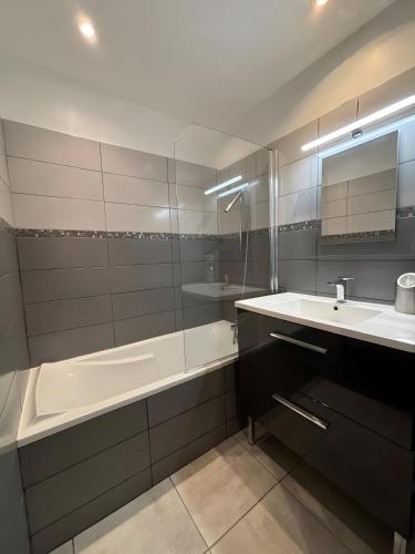 une salle de bain avec une baignoire et un lavabo et une baignoire dans l'établissement Plage du Couchant, à La Grande Motte