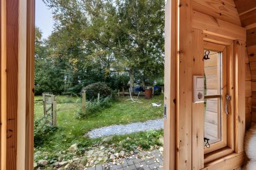a door to a cabin with a view of a yard at das Fass de Olle Uhlhoff in Barlt