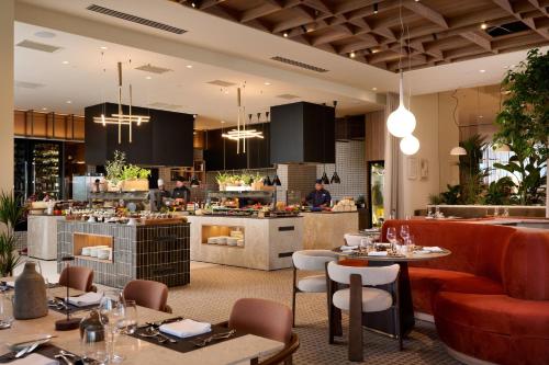 um restaurante com mesas e cadeiras e um balcão em Arba Resort, Valamar Collection em Rab