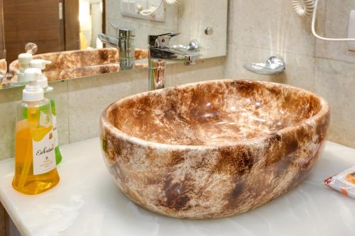 a bathroom sink with a large wooden bowl on a counter at Avanti Manors- Service Apartments in Gurgaon