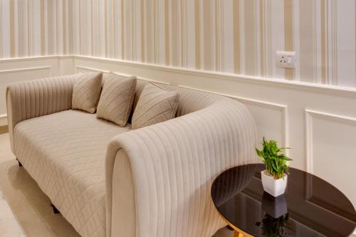 a white couch in a living room with a table at Avanti Manors- Service Apartments in Gurgaon