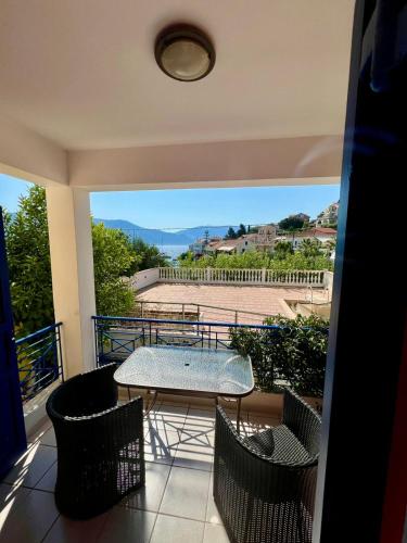 a balcony with a table and chairs and a view at Fiskardo Beach Apartments in Fiskardho