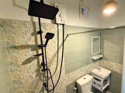 a bathroom with a shower and a toilet at สวนไมตรีจิต รีสอร์ท in Ban Khlong Si