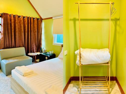 a bedroom with a bed and a yellow wall at สวนไมตรีจิต รีสอร์ท in Ban Khlong Si