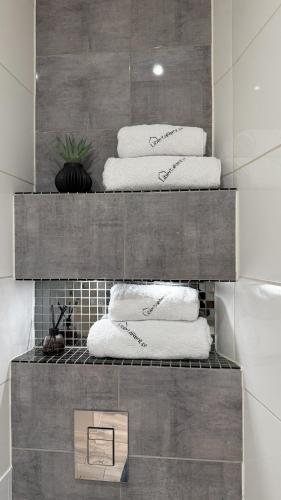 a stack of towels on a shelf in a bathroom at StayZdrój by LibertaRent in Wałbrzych