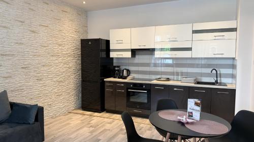 cocina con mesa, sillas y barra en StayZdrój by LibertaRent, en Wałbrzych