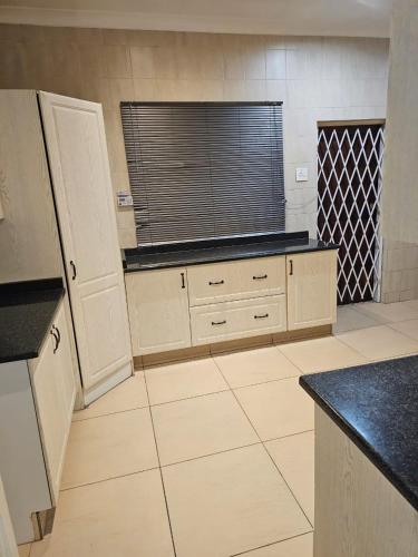 a large kitchen with a window and a counter top at WiseStar Guest House in Johannesburg