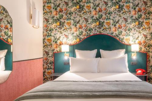 une chambre avec un lit avec un papier peint fleuri dans l'établissement Hôtel Brittany, à Paris