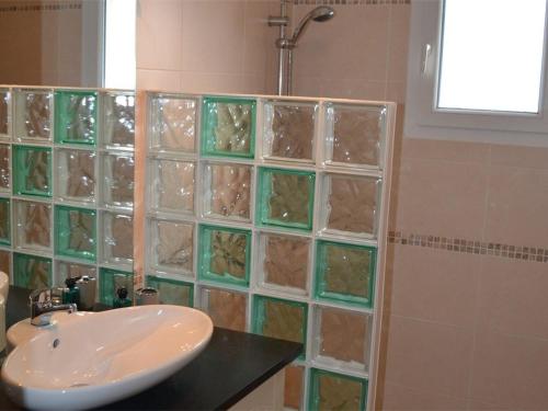 La salle de bains est pourvue d'un lavabo et d'une douche avec du carrelage en verre. dans l'établissement Villa 4* à Vallon-Pont-d'Arc avec piscine privée, jardin clôturé, climatisation et WiFi - FR-1-382-63, à Vallon-Pont-dʼArc