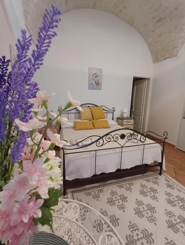 a bedroom with a bed with yellow pillows and purple flowers at A casa di Carmen in Modica