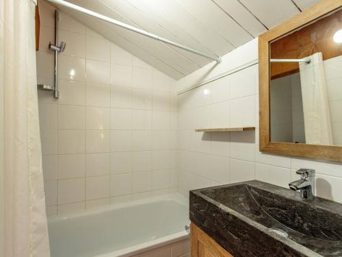 une salle de bain avec un lavabo et une baignoire dans l'établissement Chalet rénové skis aux pieds, 4 chambres, Plagne Soleil - FR-1-351-144, à La Plagne Tarentaise
