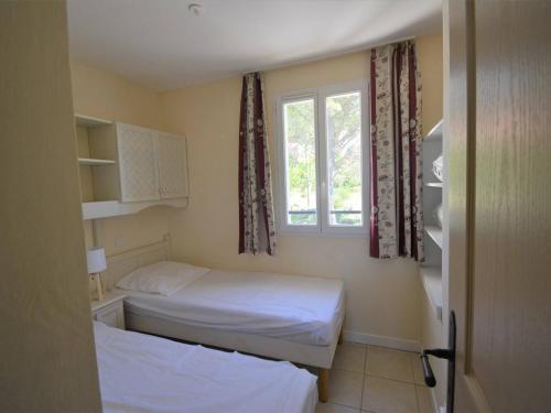 une petite chambre avec deux lits et une fenêtre dans l'établissement Maison 6 pers. avec Terrasse Privée, 3 Pièces en Duplex – Wifi & Animaux Admis - FR-1-382-119, à Grospierres