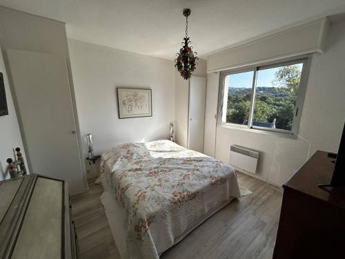 une chambre blanche avec un lit et une fenêtre dans l'établissement Bel appartement avec terrasse et vue mer à Cavalaire-sur-Mer - FR-1-100-361, à Cavalaire-sur-Mer