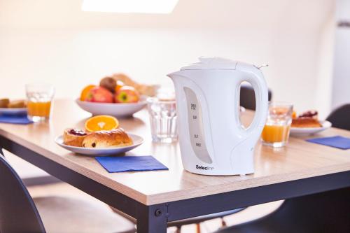 a table with a tea kettle on it with food at TH 102 Appartement F2 en duplex tout confort 1 à 3 personnes in Thann
