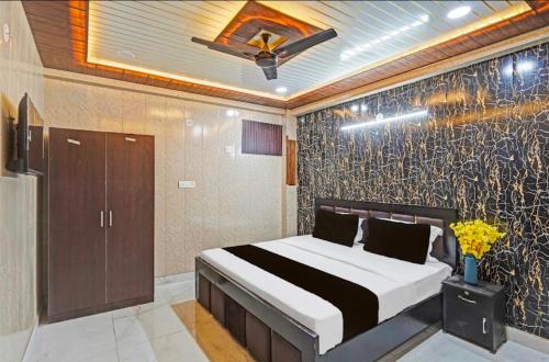 a bedroom with a bed and a wall at Vrishti Residency & Hotels in Greater Noida