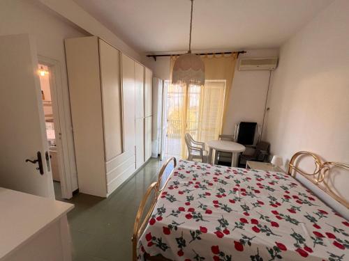 une chambre avec un lit recouvert d'une couverture fleurie dans l'établissement Villa Melina Affittacamere, à Santa Maria di Castellabate