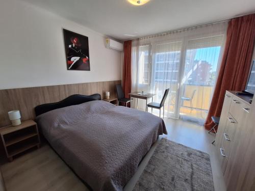 a bedroom with a bed and a desk and a window at Sunrise Apartman in Siófok