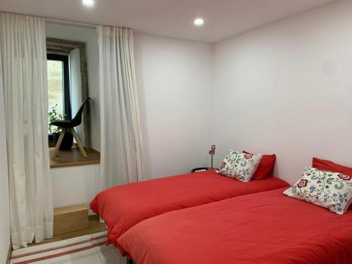 a bedroom with a red bed and a window at Casa da Fonte in Mangualde