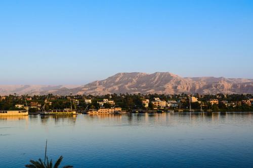 a view of a body of water with mountains in the background at Winter apartment in Luxor