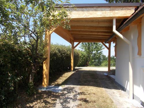 a wooden pergola on the side of a building at Apartma Prima in Podbočje