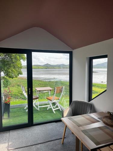 a living room with a view of a table and chairs at Coastal Escape with Ocean and mountain views 