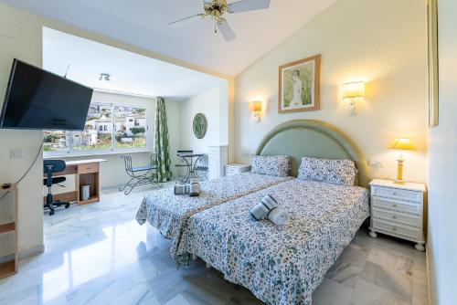 ein Schlafzimmer mit einem Bett und einem Flachbildfernseher in der Unterkunft Townhouse Cortijos de La Hidalga in Torremuelle