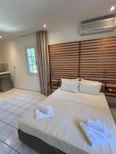 a bedroom with a large bed with towels on it at Physis Oikos Beachfront Apartments in Skiathos Town