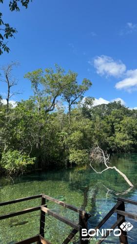a fence in front of a river with trees at Pousada Papaya - Bonito in Bonito
