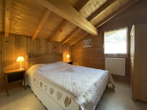 une chambre avec un lit dans une cabane en bois dans l'établissement Duplex cosy 4 pers à Crest-Voland, proche pistes, parking, wifi - FR-1-733-74, à Crest-Voland