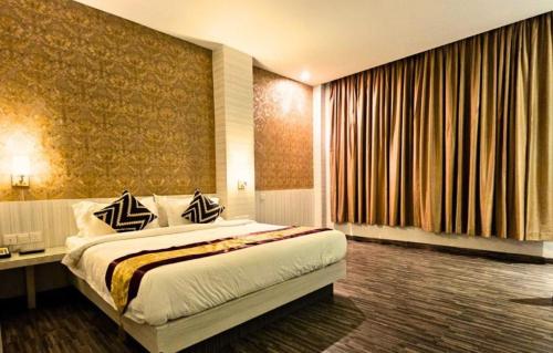 a hotel room with a bed and a large window at Alltrue Sydney Hotel Batam Center in Batam Center