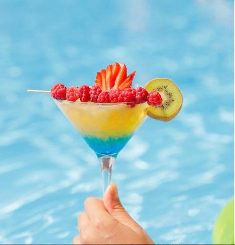 a person holding a drink with fruit on it at Colette Hotel in Yerevan