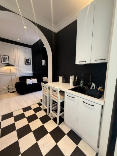 - une cuisine avec des placards blancs et un sol en damier dans l'établissement Lingotto Penthouse, à Turin