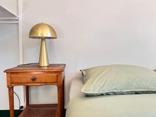 a lamp on a table next to a bed at Villa Magdala Arts & Résidence in Hyères