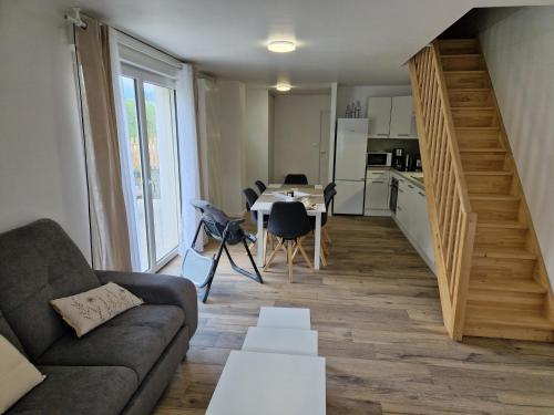 a living room with a couch and a table at Appartement rénové Au Rain Grébatte avec terrasse in La Croix-aux-Mines