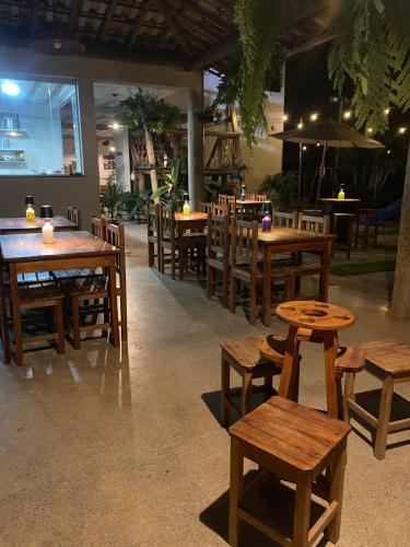 an empty restaurant with wooden tables and chairs at Pousada Rural Vista do Limoeiro in Itabira