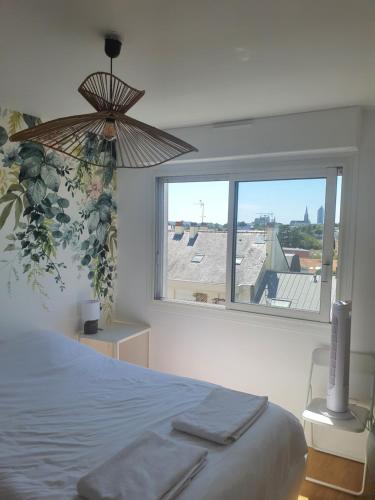 a bedroom with a bed and a large window at Appartement cosy Nantes proche gare in Nantes