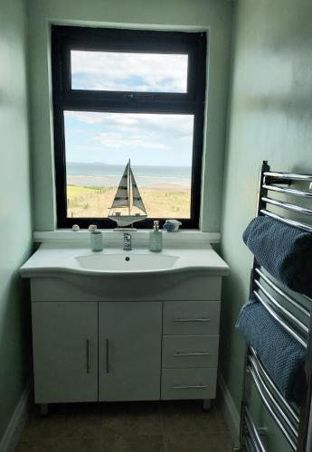 a bathroom with a sink and a window with a sail at Seaside Chill in Carrick