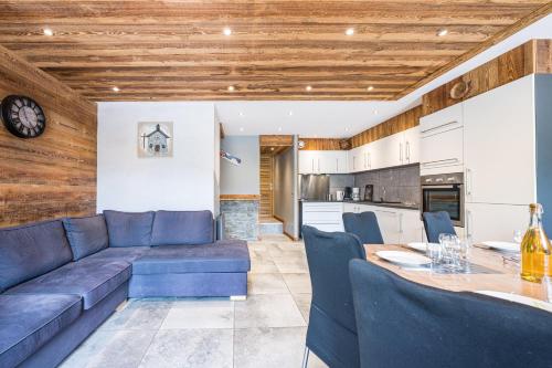 un salon avec un canapé bleu et une table dans l'établissement Chalet - Le crey rond, à Valloire
