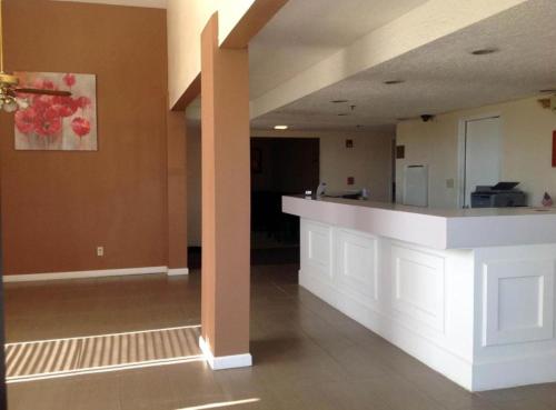 an empty lobby with a white counter in a building at Studio 6 Suites Delano, CA in Delano