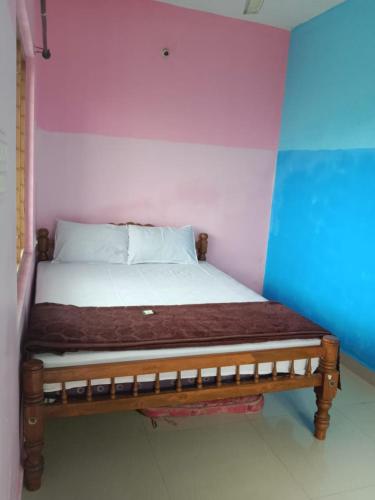 a bed in a room with a purple wall at Anaswaram holidays in Vagamon