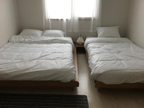 two twin beds in a room with a window at Stay Soup in Suwon